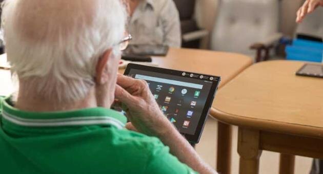 older adult man with tablet