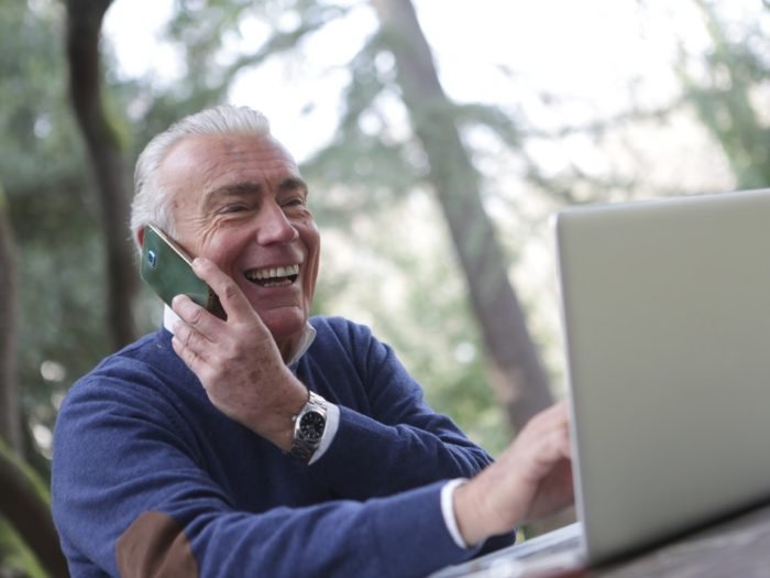 man on phone using laptop