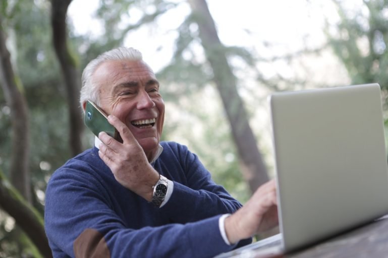 man on phone using laptop