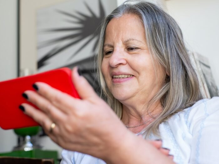 Smiling older woman using a smartphone.