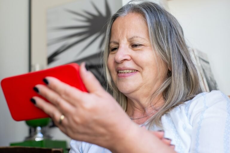 Smiling older woman using a smartphone.