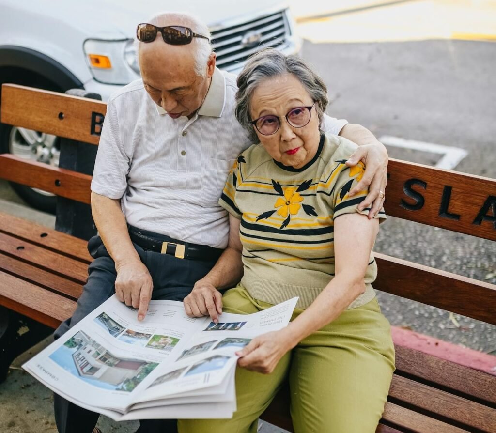 seated man and woman reading a newspaper